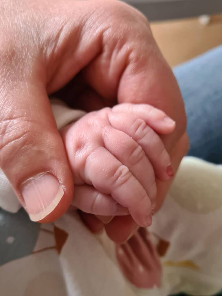 Farmor håller barnbarnets hand