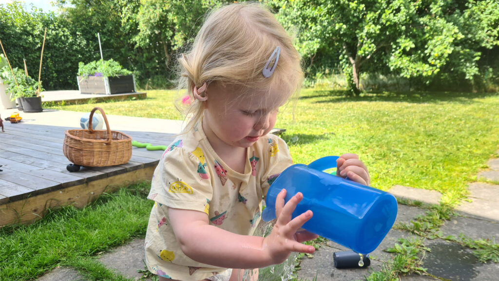 Juni häller vatten på sin mage