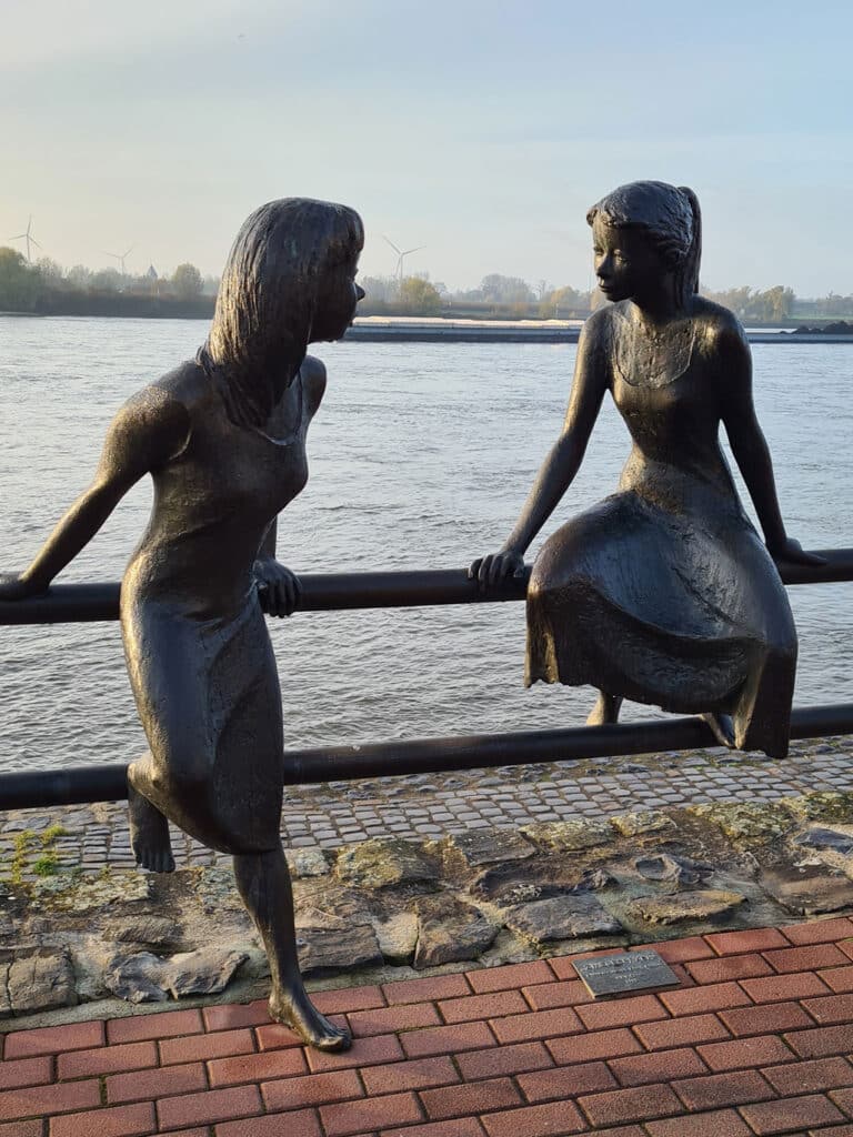 Skulptur med två pratande flickor